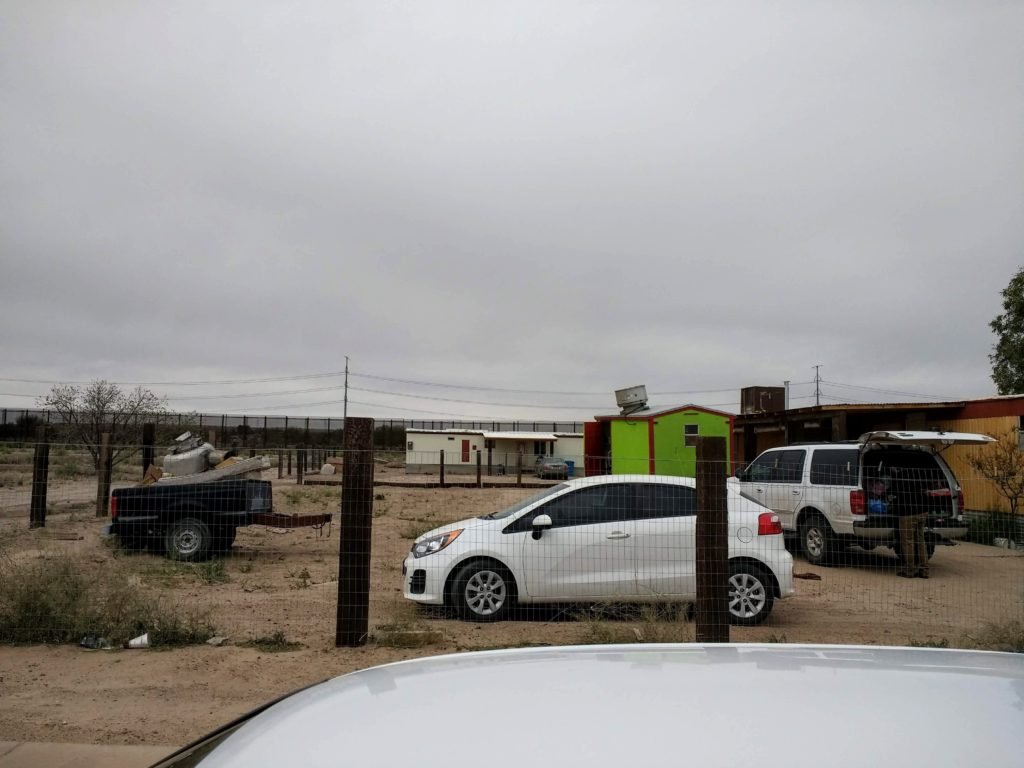 a man fixing his car by the border