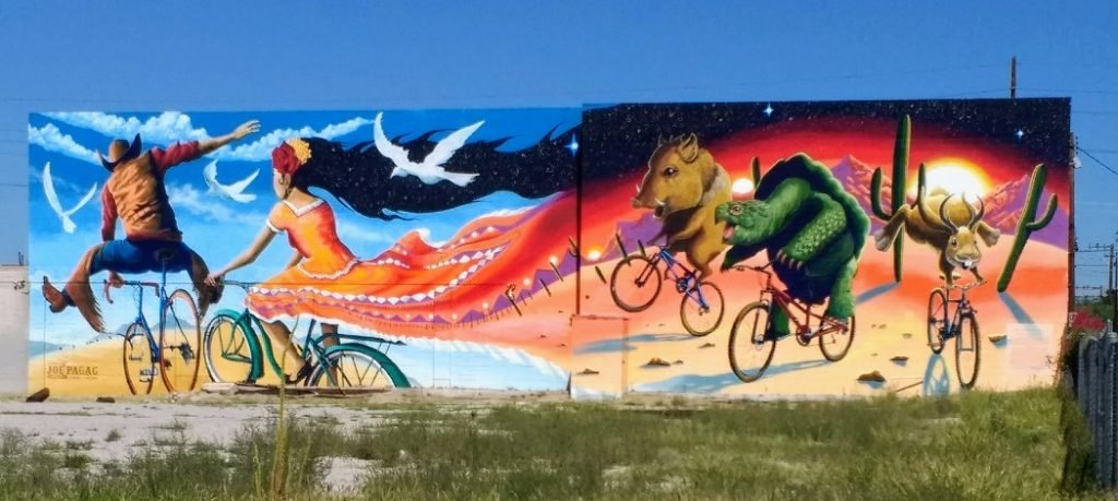 Cyclists followed by deseret creatures mural  Tucson AZ